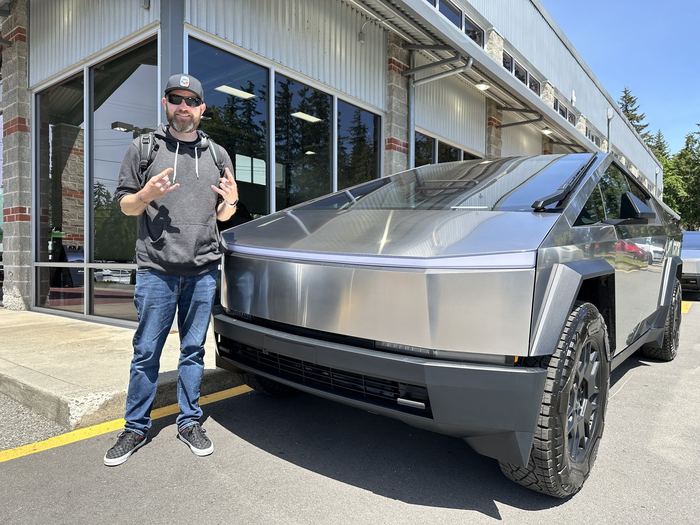 Zach standing next to his Tesla Cybertruck outside a Tesla service center.